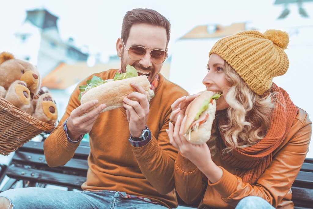 Couple eating a sandwich in the park