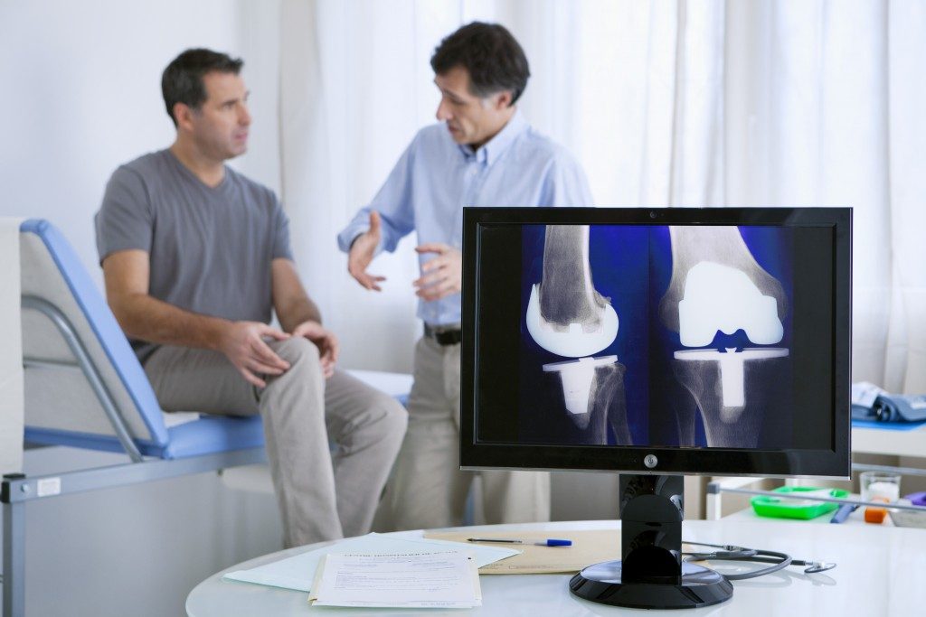 Man with knee problem consulting a doctor