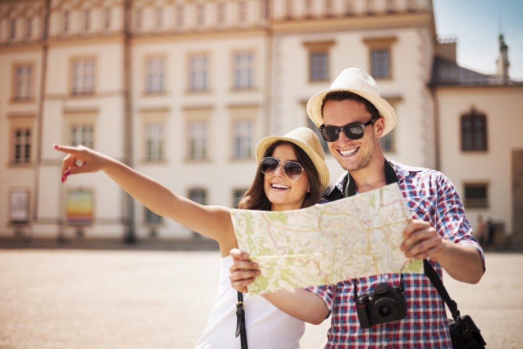 Happy tourists sightseeing wits a map