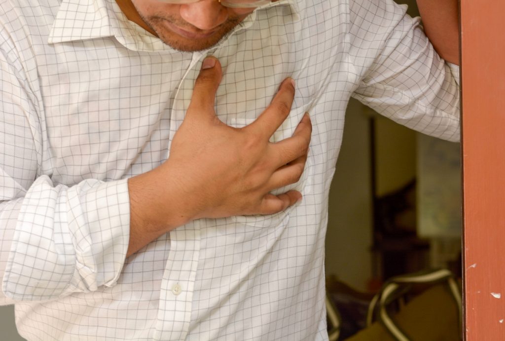 man clutching his chest