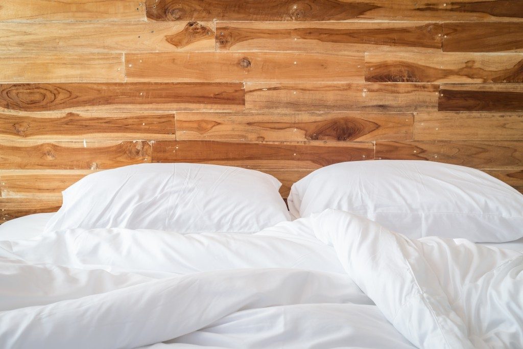 white bedding sheets with wooden headboard