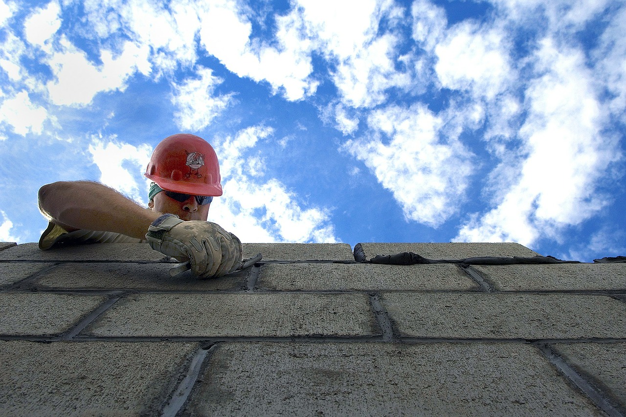 construction worker using bricks