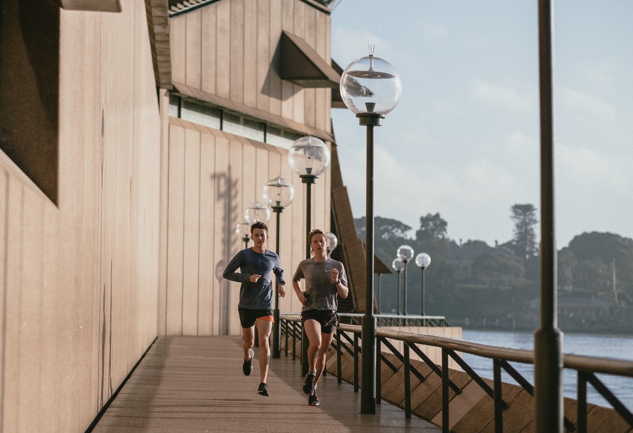 two people running on a bridge