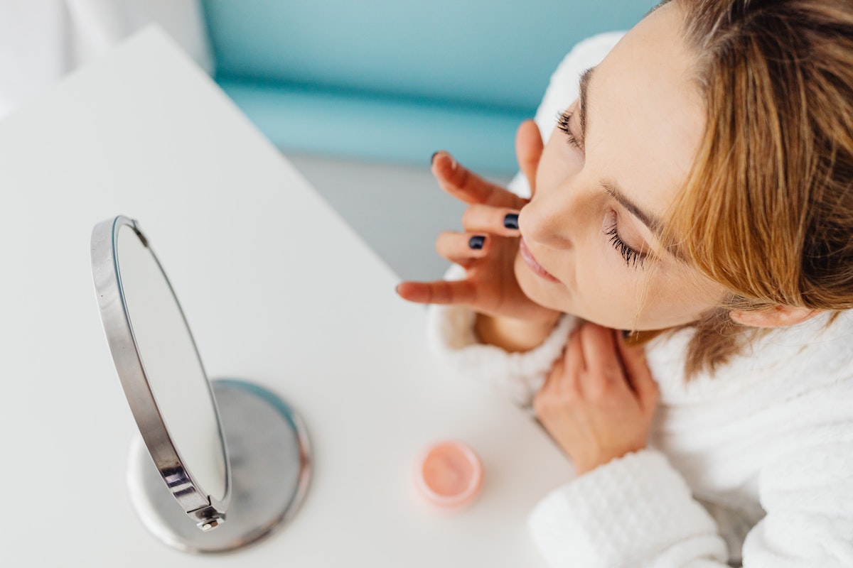 woman putting on skincare