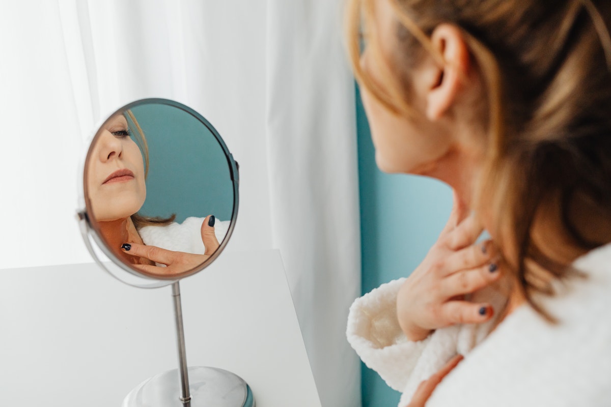 woman checking skin in the mirror