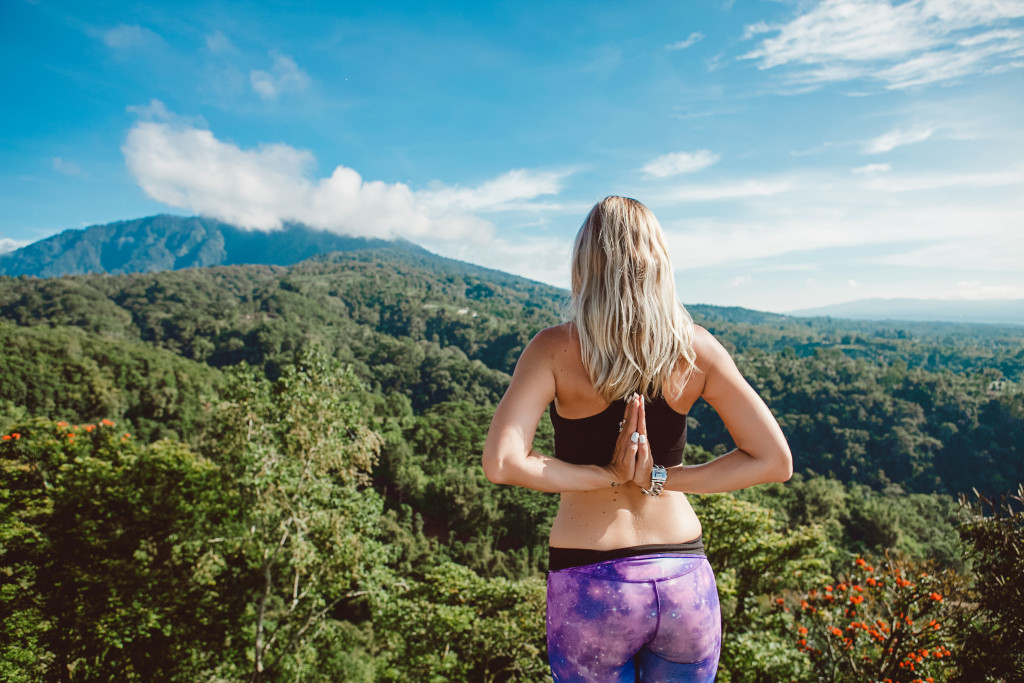 blonde woman meditating and doing yoga in nature