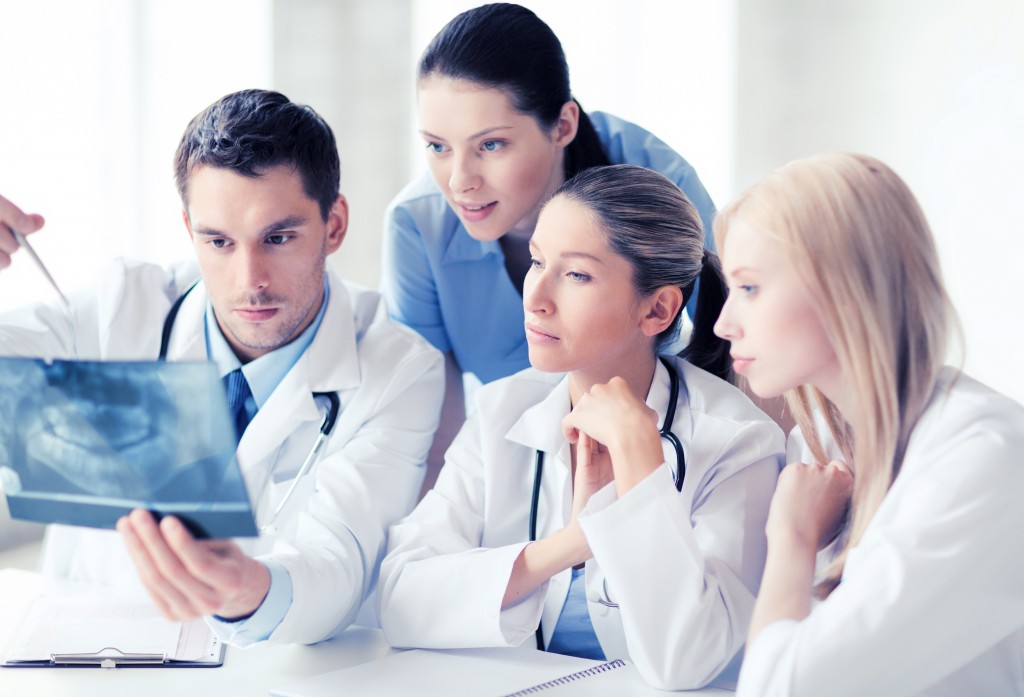 A group of dental care professionals looking at a dental x-ray