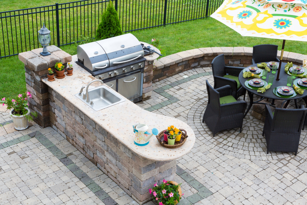 outdoor kitchen with grill, cooker, and dining set