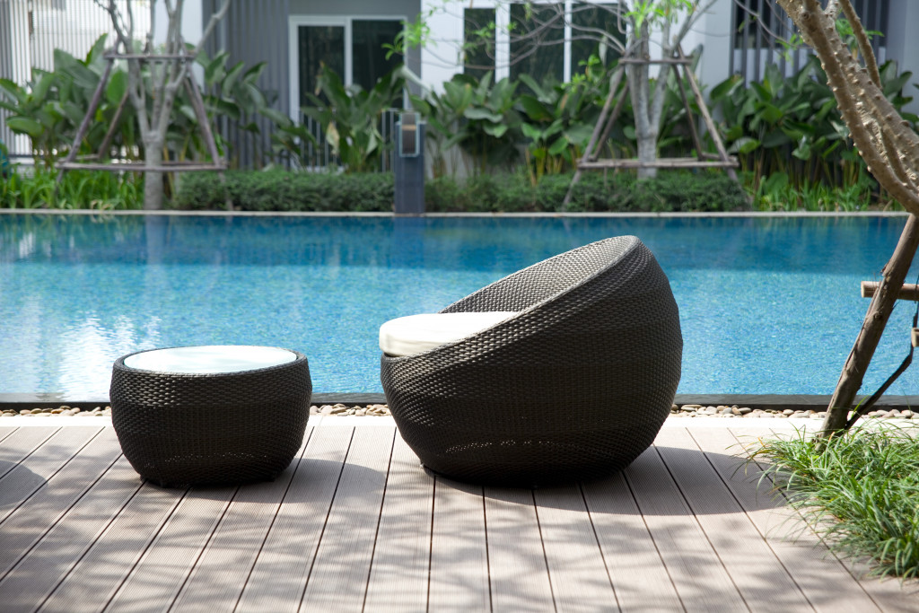 outdoor chair and table next to a pool