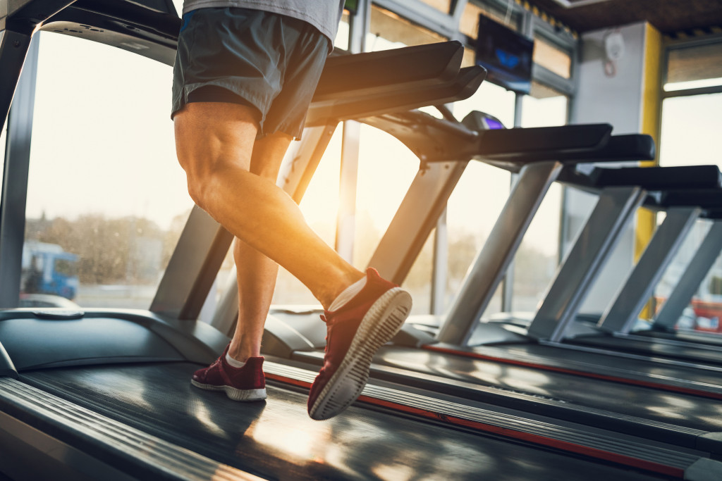 man doing cardio with sun out in gym