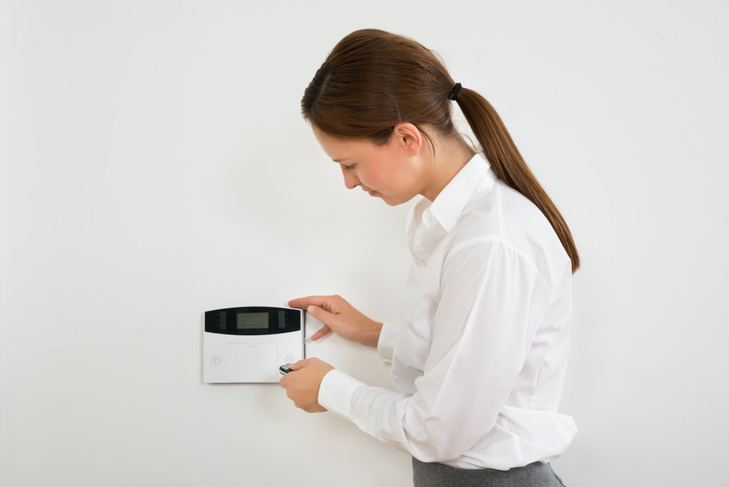 woman setting security system at home 