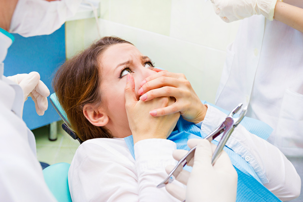 A woman looking shocked, refusing to have a dental procedure