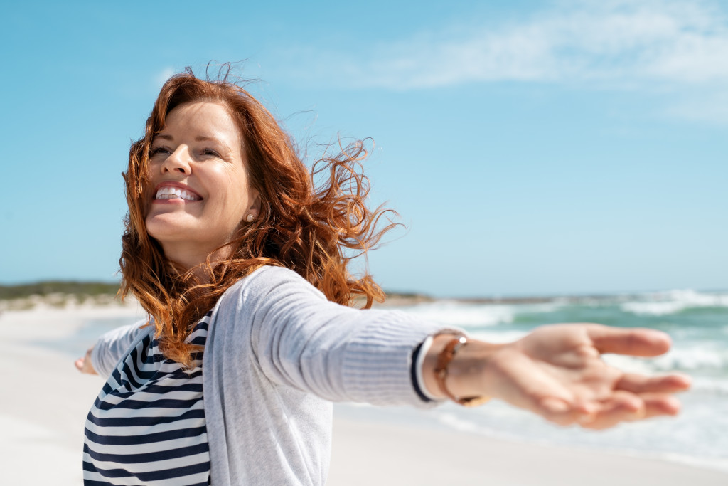 carefree woman by the beach enjoying herself