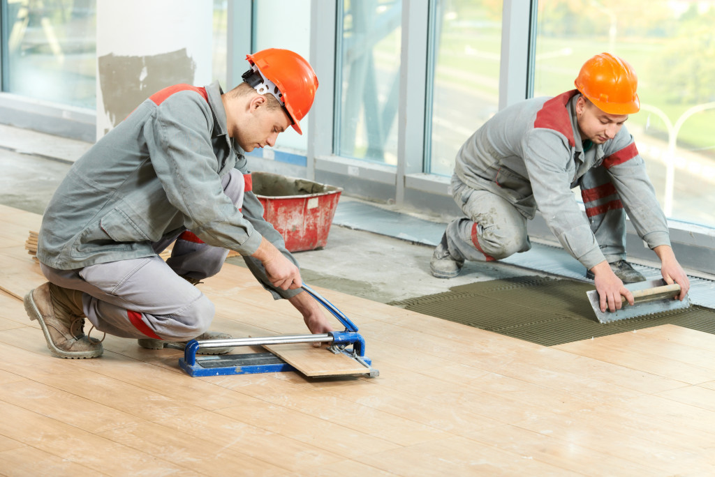 men installing new tiles to floor