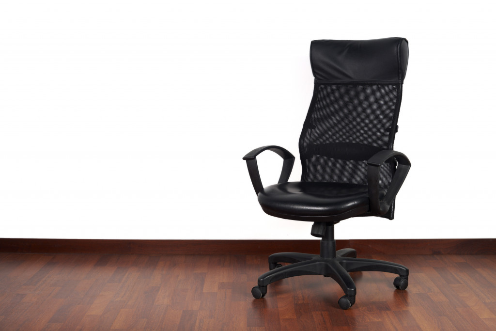 An isolated office chair on a hardwood floor