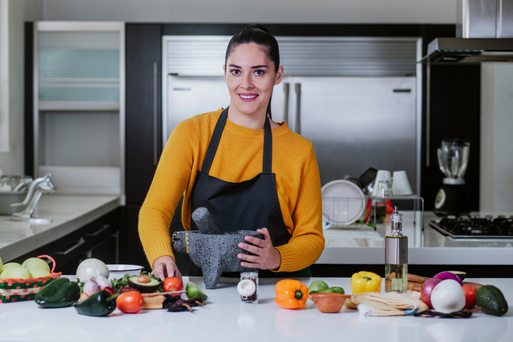 woman smiling while preparing healthy food in the kitchen