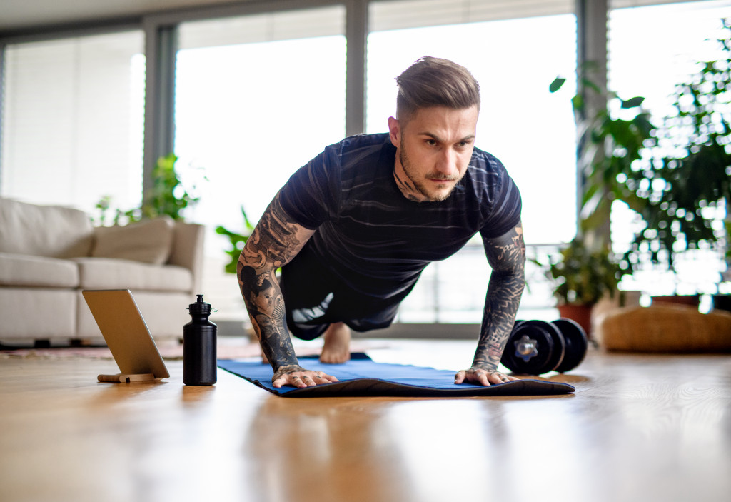 A fit man doing push ups at home