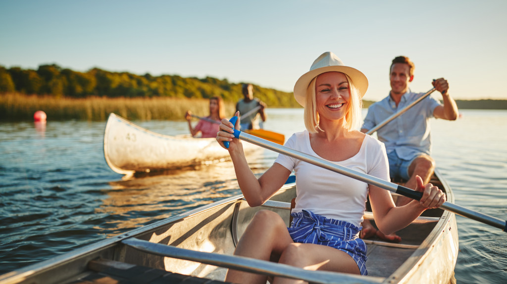 A group of people paddling a canoe on a lake on a sunny day