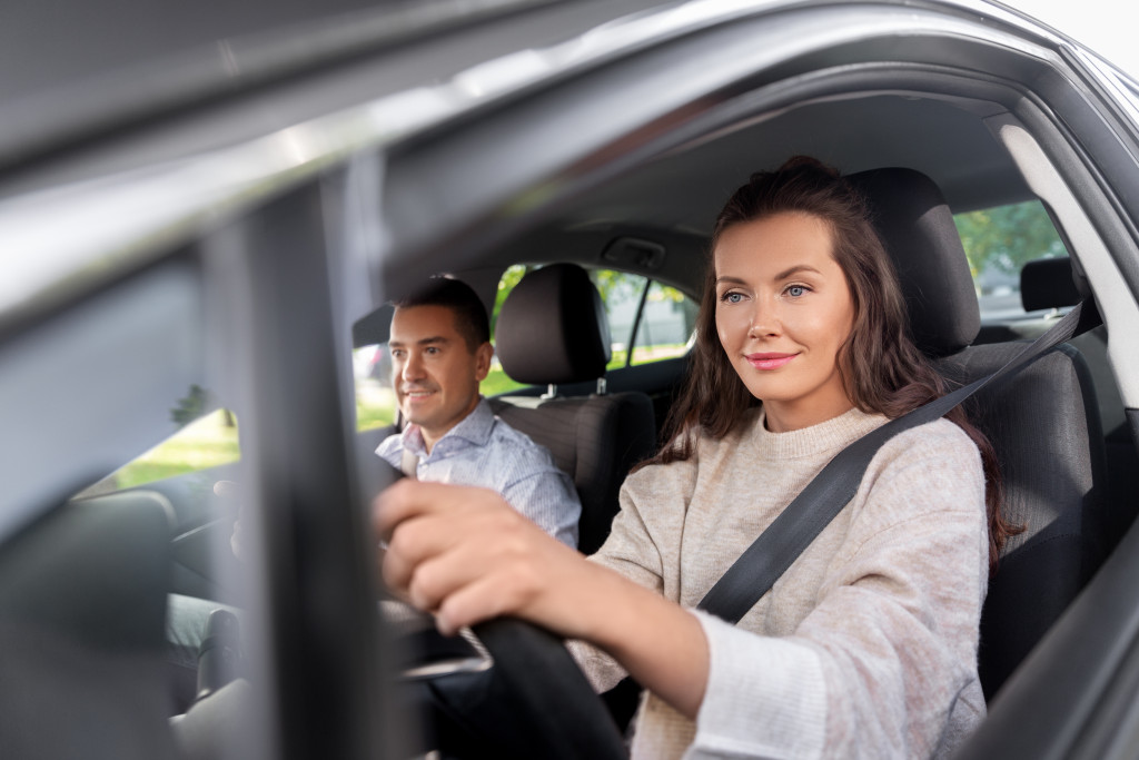 A woman getting a refresher course on driving in a driving school with an instructor