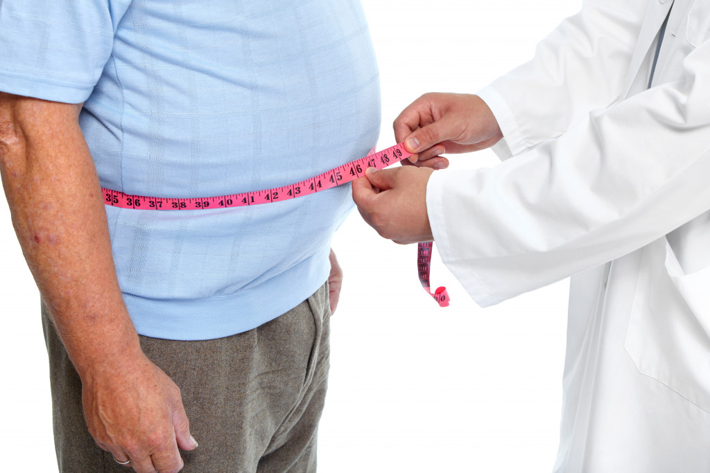 Obese man getting measured