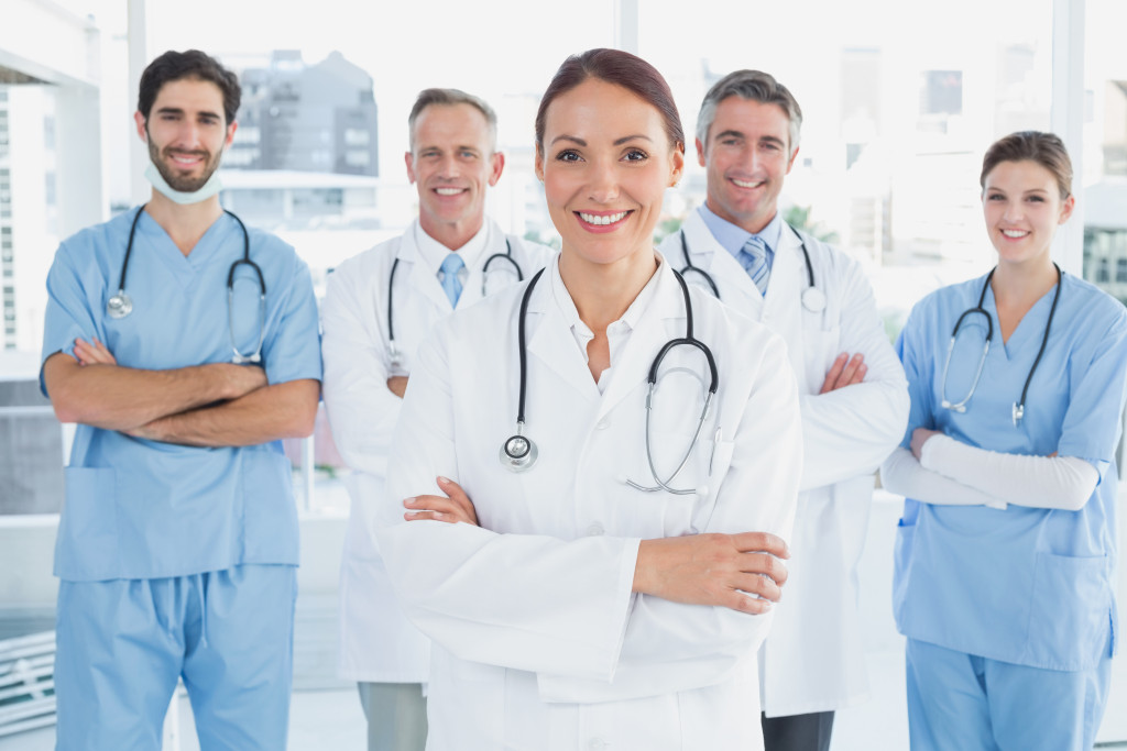 Smiling medical professionals standing with their arms crossed.