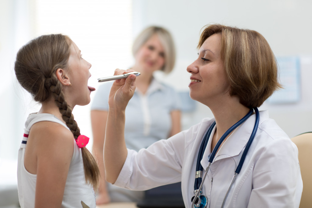 a doctor checking girl's mouth