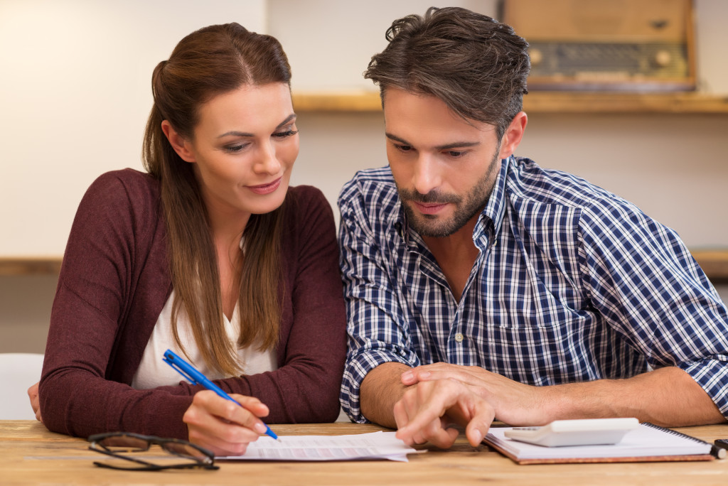 wife holding a pen making a decision with husband