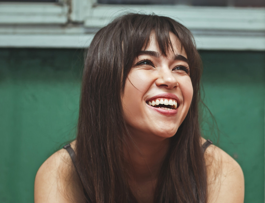 Young woman smiling while sitting down. 