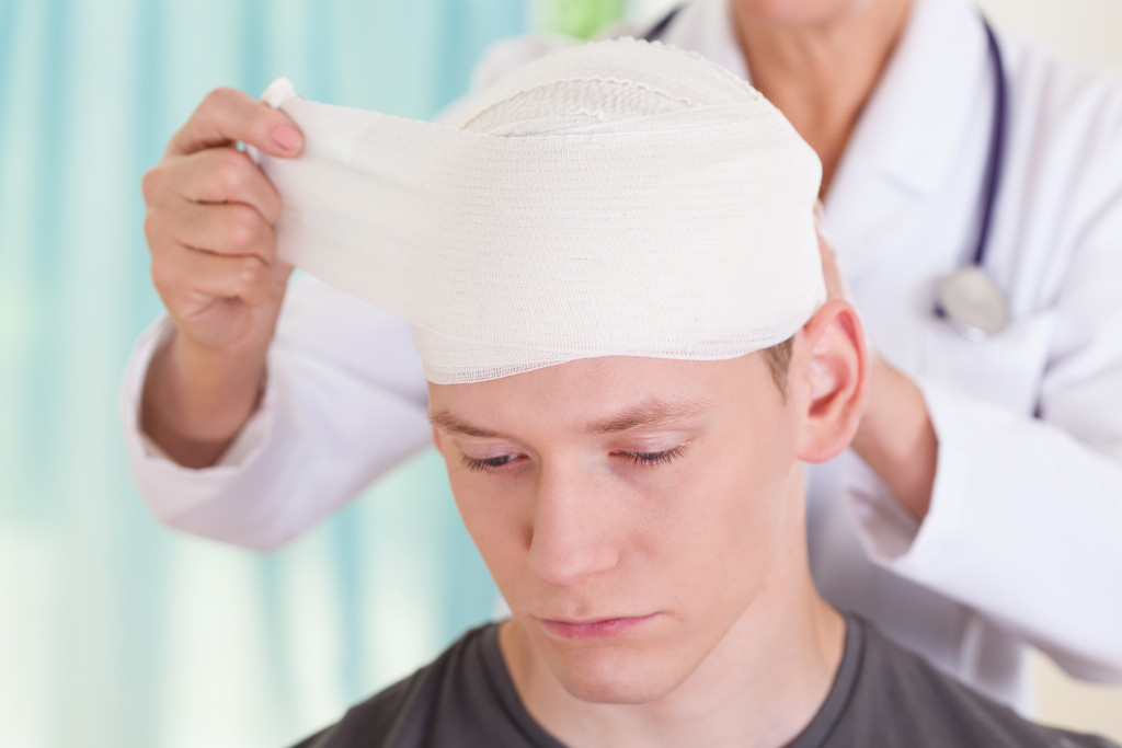 A doctor wrapping a man's head in bandages