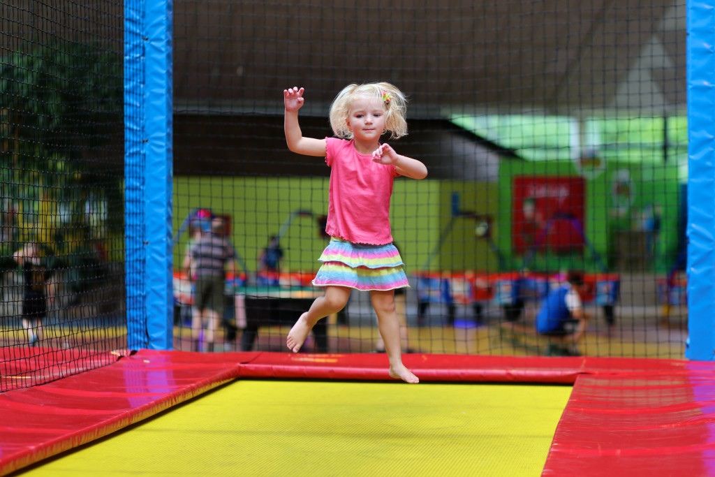 Young girl having fun at a trampoline park.