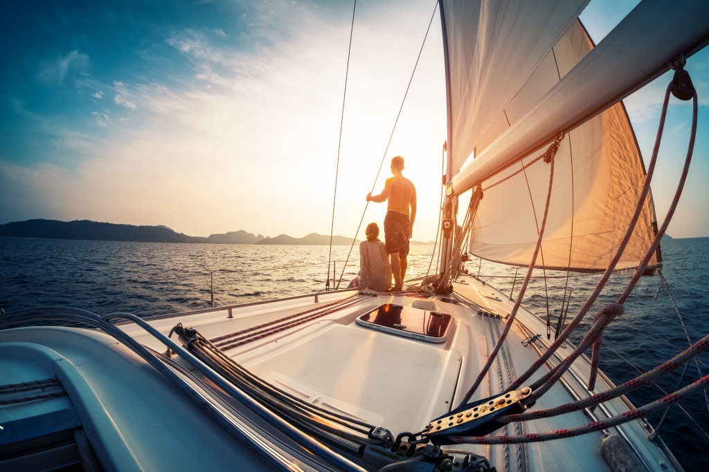 man and woman boating in a calm sea with sun setting beyond