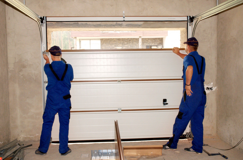 Two workers installing shelves in a garage