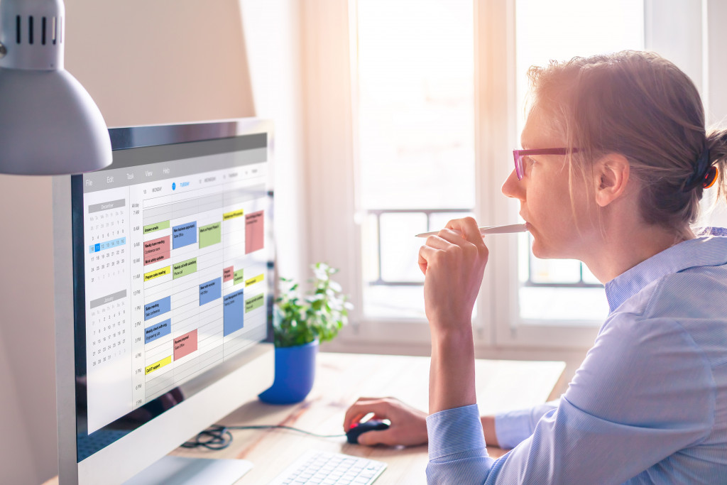 A woman looking at an online scheduling app through her PC