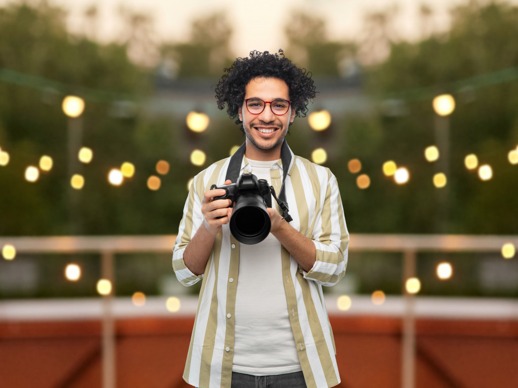 A man holding a camera on a rooftop