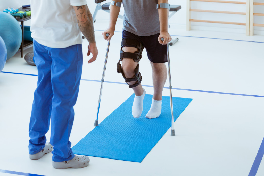 A man learning to use crutches in physical therapy