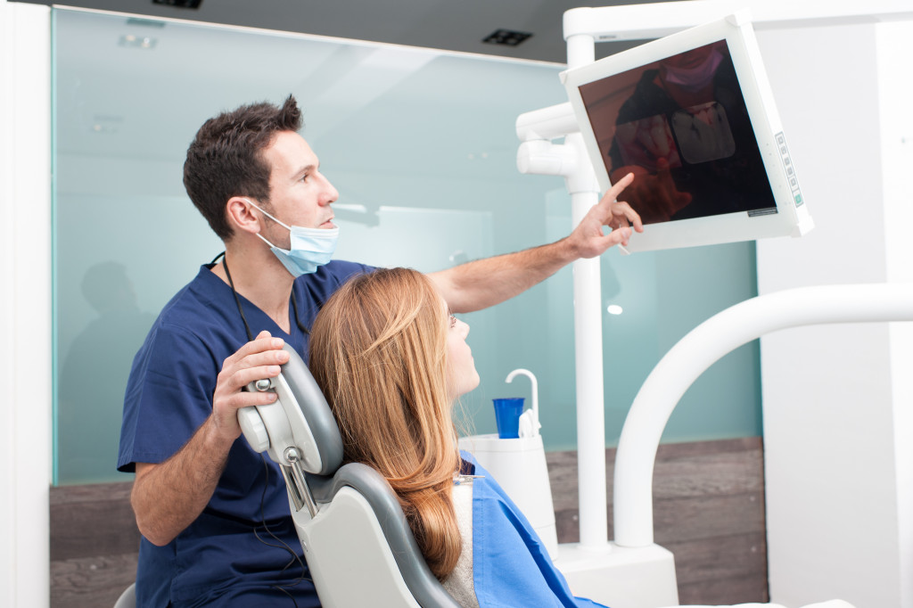 dentist showing xray image of teeth to female patient