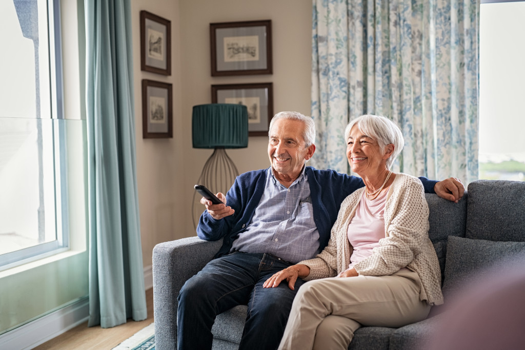 senior couple happily watching TV in their simple home