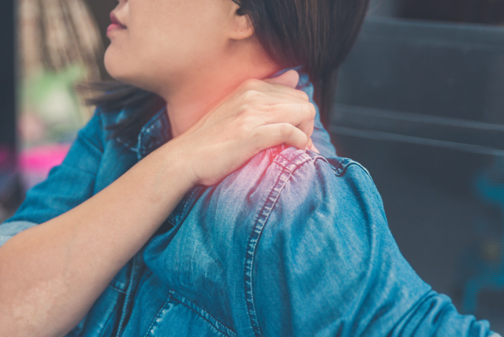 woman holding her shoulder in pain