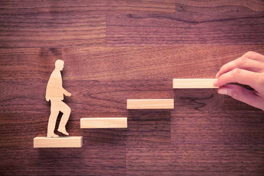 A wooden figure of a person climbing stairs