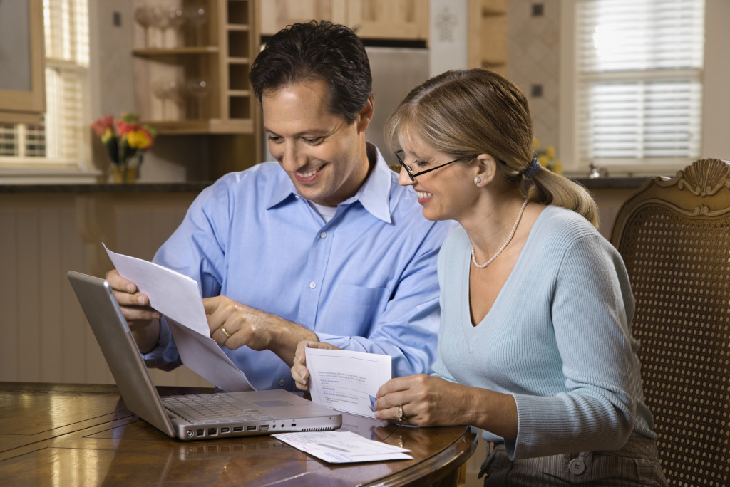 Mature couple checking their finances and expenses at home.